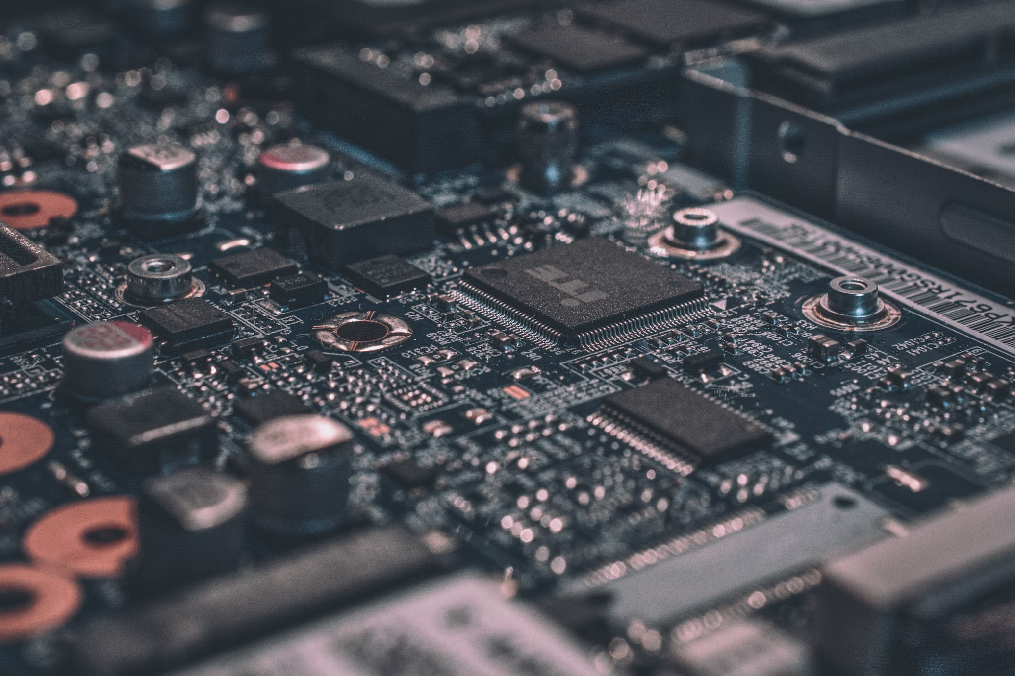Close-up of a computer motherboard showing integrated circuits, capacitors, and microchips